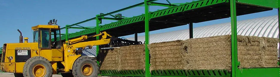 Stacked bales of hay under cover ready for delivery